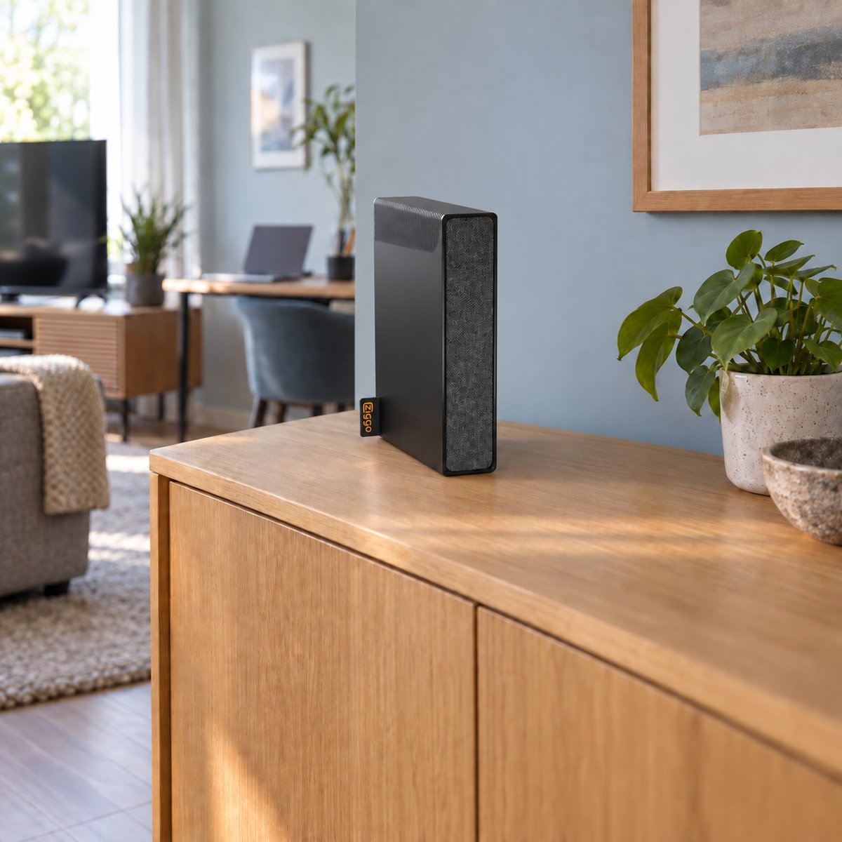 Zwart Ziggo SmartWifi-modem op een houten kast in een thuiswerkruimte